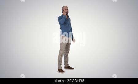 Serious arab talking on the phone on gradient background. Stock Photo