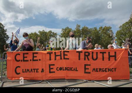 London, UK. 10th September 2020. Members of Extinction Rebellion climate change action group seen behind a large orange banner with sign writing on Parliament Square during their protest actions. Credit: Joe Kuis / Alamy News Stock Photo