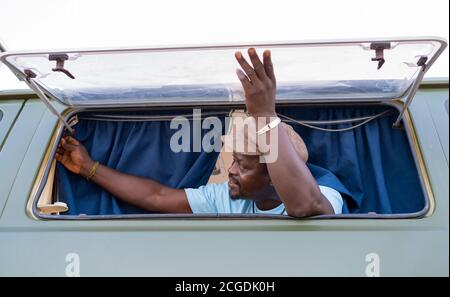 black african american man in the window of his camper van Stock Photo