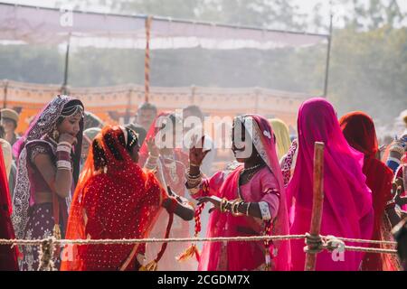 Indian woman dancing in brightly colored clothing at Jaisalmer Desert Festival, Rajasthan, India. Stock Photo