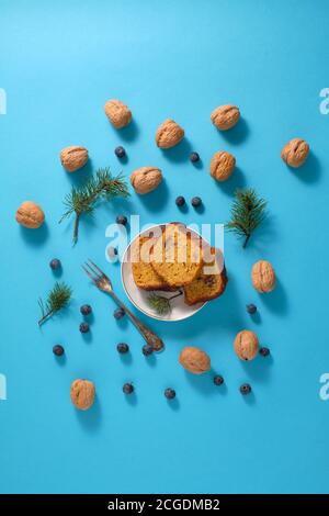 Pieces of walnut and blueberry sponge cake on blue background Stock Photo