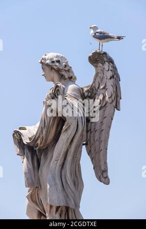 Rome, Italy - June 28, 2010: One of the famous statues of angels, the one with the dices, on the Sant'Angelo bridge near the Castle of the same name. Stock Photo