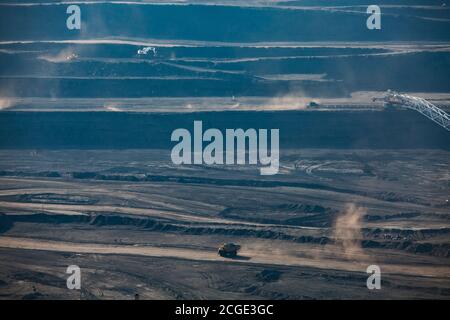 Open pit extraction of coal in quarry 'Bogatyr', Ekibastuz, Kazakhstan. Quarry truck and excavator on the road. Stock Photo