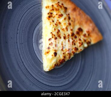 Photo texture of a slice of pizza with cheese on a plate in a cafe Stock Photo