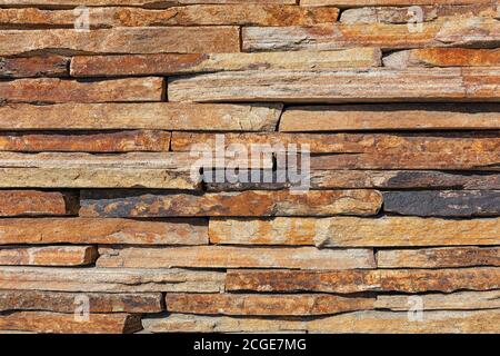 Wall background and texture of brown old slate stone, close-up. Stock Photo