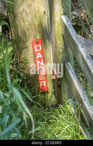 wooden post with danger sign on mountain cliff Stock Photo - Alamy