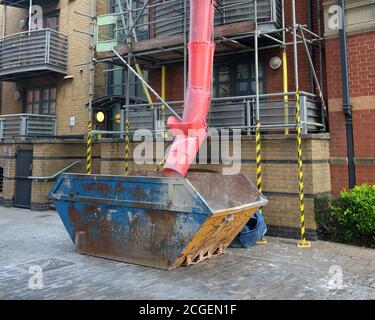 September 2020 - Rubbish chute into a skip on a refurbishment project. Stock Photo
