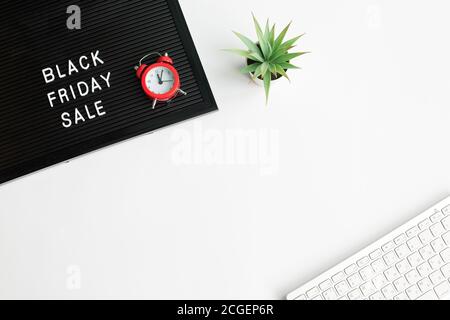White text Black Friday Sale on black letter board with computer keyboard and Alarm Clocks Stock Photo