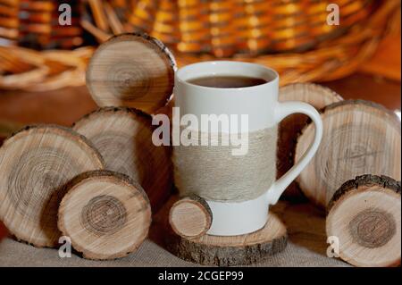 white Cup decorated with twine rope and round wooden slices of natural wood around Stock Photo