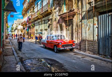 Havana, Cuba, July 2019, urban scene with a red 50s Chevrolet car parked in the street in the oldest part of the city