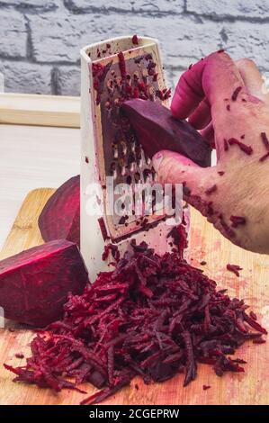 grate beetroot on a grater, fresh beet grated Stock Photo