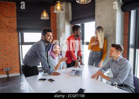 Diverse young people in casual cloth, working together on making marketing research. University students share opinions during break sitting in cowork Stock Photo
