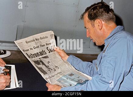 (17 April 1970) --- Astronaut James A. Lovell Jr., Apollo 13 mission commander, reads a newspaper account of the safe recovery of the problem plagued mission. Lovell is on board the USS Iwo Jima, prime recovery ship for Apollo 13 Stock Photo