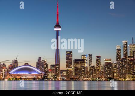 A photograph of the Toronto skyline at sunset. Showing a wonderful colourful sky and buildings in the distance. Taken from across Lake Ontario Stock Photo