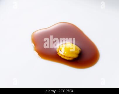 Soy sauce and chili pepper dripping on a white plate. Japanese red pepper soy sauce Stock Photo