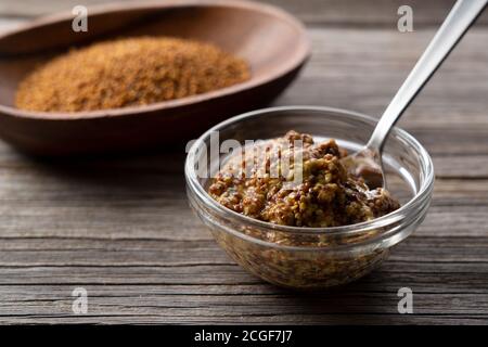 Mustard sauce set against the backdrop of an old tree. Scoop out that sauce with a spoon. Stock Photo