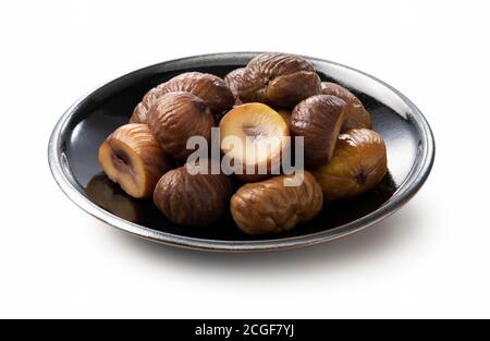 Peeled sweet chestnuts in a plate on a white background Stock Photo