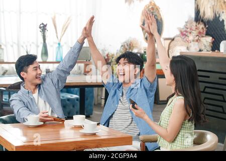 Young friends celebrate in a coffee shop Stock Photo