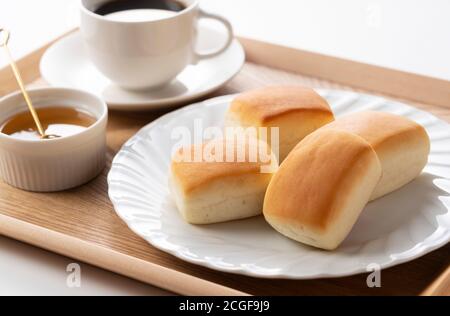 Dinner rolls, coffee and honey on a wooden tray. Breakfast Image. Stock Photo