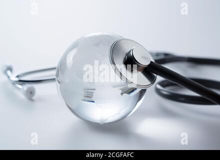A glass globe and stethoscope on a white background. Stock Photo