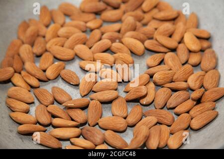 Closeup of roasting raw almonds with selective focus Stock Photo