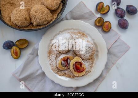 Typical Austrian plum dumplings made of leavened dough and fresh plums Stock Photo