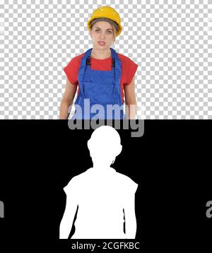 Woman in construction outfit talking to camera while walking, Alpha Channel Stock Photo