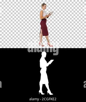 Businesswoman using electronic tab walking, Alpha Channel Stock Photo