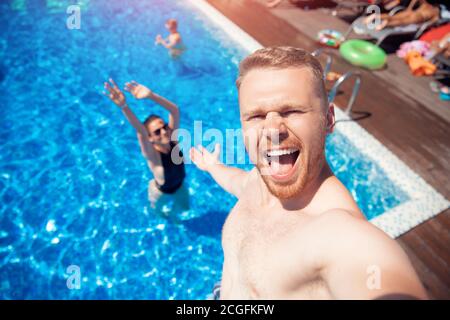 Selfie photo loving Caucasian couple friends on vacation on background of pool summer travel Stock Photo