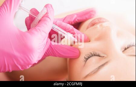 Woman getting rejuvenating facial injection beauty and cosmetology procedure for tightening and smoothing wrinkles on face skin Stock Photo