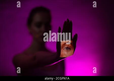 Blind woman with eye on her hand palm in dark Stock Photo