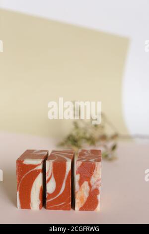 Three red handmade organic soaps with essential oils on background with copy space. Stock Photo
