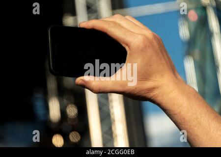 Hand holding a smartphone with a black screen and takes a close-up of what is happening Stock Photo