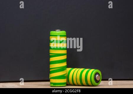 Two yellow-green batteries, close-up on a black background. Space for text Stock Photo