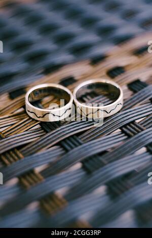 Gold wedding rings patterned on a gray woven texture. Stock Photo