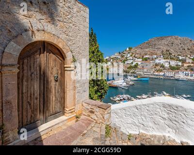 The impressive old entrance over the port of Hydra in Greece speaks of the island's rich past, when the ships returned carrying wealth and culture. Stock Photo