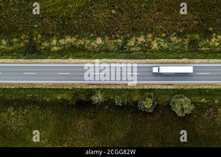 Large freight transporter semi-truck on the road, aerial view top down from drone pov Stock Photo
