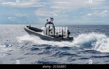 US Navy A Rigid Hull Inflatable Boat (RHIB) is raised from the water to ...