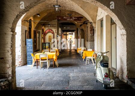 Morcote Switzerland , 1 July 2020 : Morcote village scenic view of arched gallery street with pizzeria restaurant entrance and Piaggio scooter in the Stock Photo