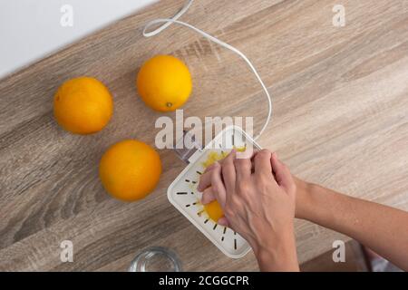 Woman squeezing oranges in the kitchen Stock Photo