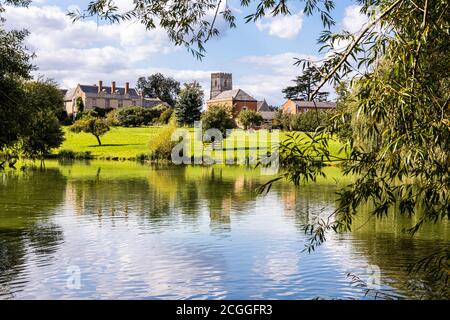 Maisemore Court and St Giles church viewed across the lake in the Severn Vale village of Maisemore, Gloucestershire UK