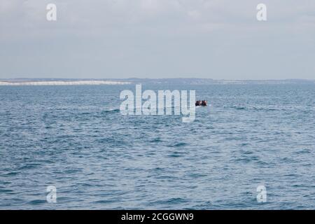 English Channel, Kent, UK. 11th September 2020: Migrant boat spotted in the English Channel on a day multiple boats attempted the crossing. This rigid inflatable was spotted in the SW shipping lane and the Coastguard were alerted to their presence. The Kent and Dover coastline beyond. Credit: adp-news/Alamy Live News Stock Photo