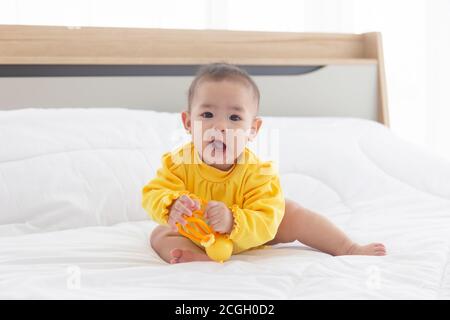 Asian babies are playing baby toys in bed. Stock Photo