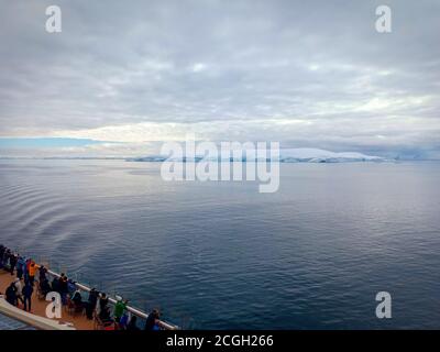 passengers watching glacier in polar region Stock Photo