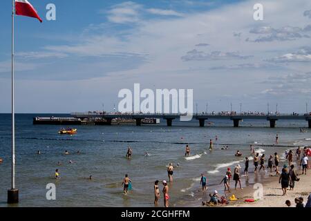 People on the Polish Baltic Sea beach here in Kolobrzeg, Kolberg Summer 2020. Stock Photo