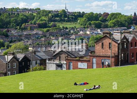 Cork city, Ireland - 16th May 2017:  people relaxing and enjoying the sunny weather in bell's field park overlooking houses in Cork city. Stock Photo