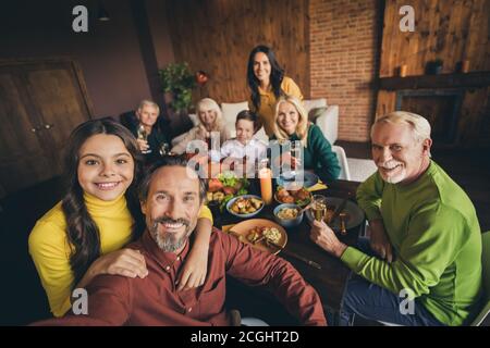 Self-portrait of attractive cheerful family brother sister gathering eating festal luncheon meal dish autumn fall harvest celebration embracing at Stock Photo