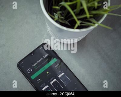 Lod, Israel - July 8, 2020: Modern minimalist office workspace with black mobile smartphone with Speedtest app play store page on marble background. T Stock Photo