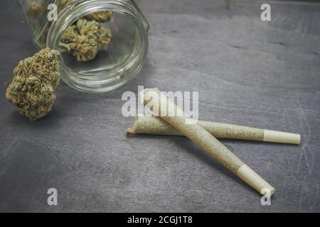 Pre-rolled CBD medical marijuana and hemp leaves on black wood background. Organic and natural hemp-based cosmetic and beauty products. Cannabis. Stock Photo