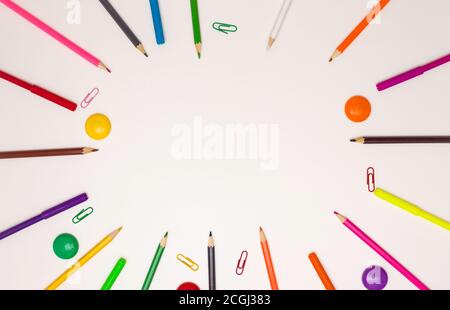 Background for school and student design. Colored pencils in the form of a frame around the free space. White background, top view. Stock Photo